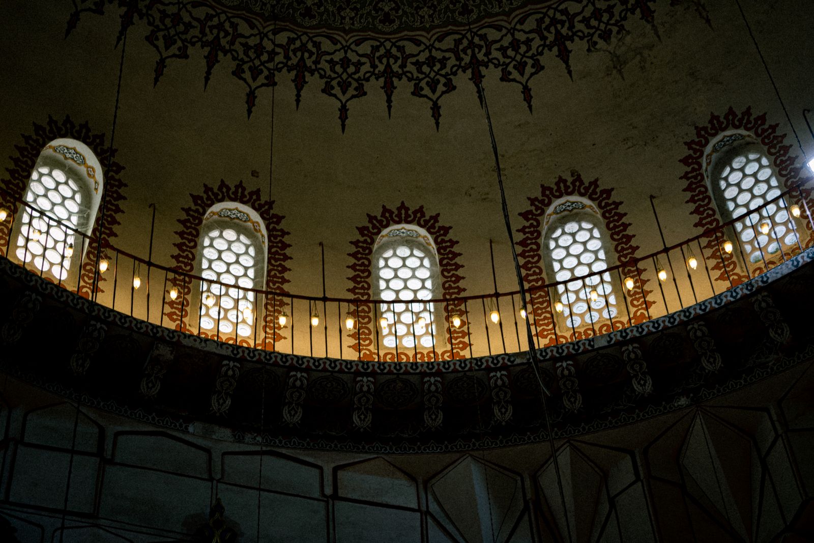 Arched windows glowing inside a mosque dome